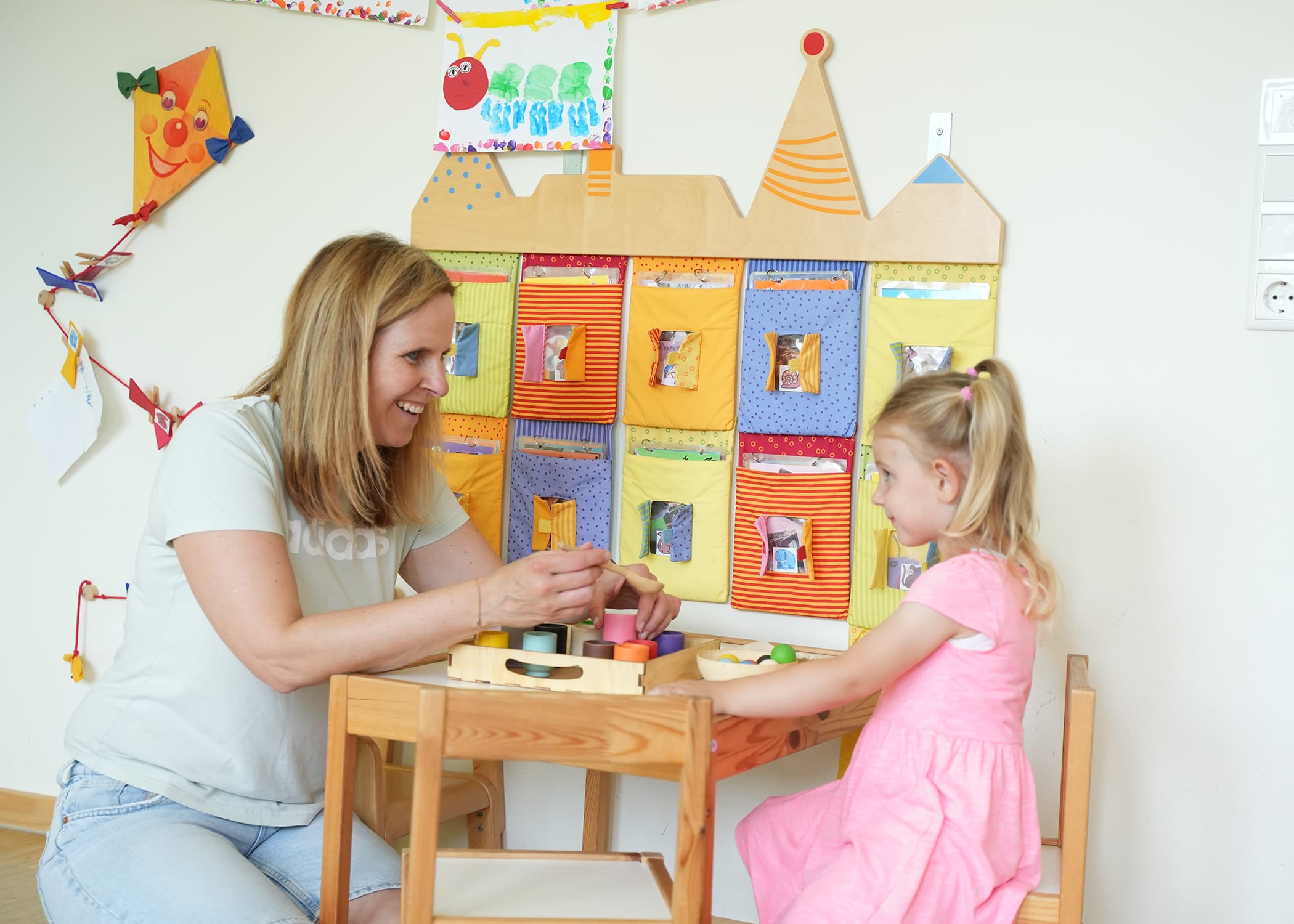 Raumbilder (50) Kinderpflegerin spielt mit Kind am Tisch